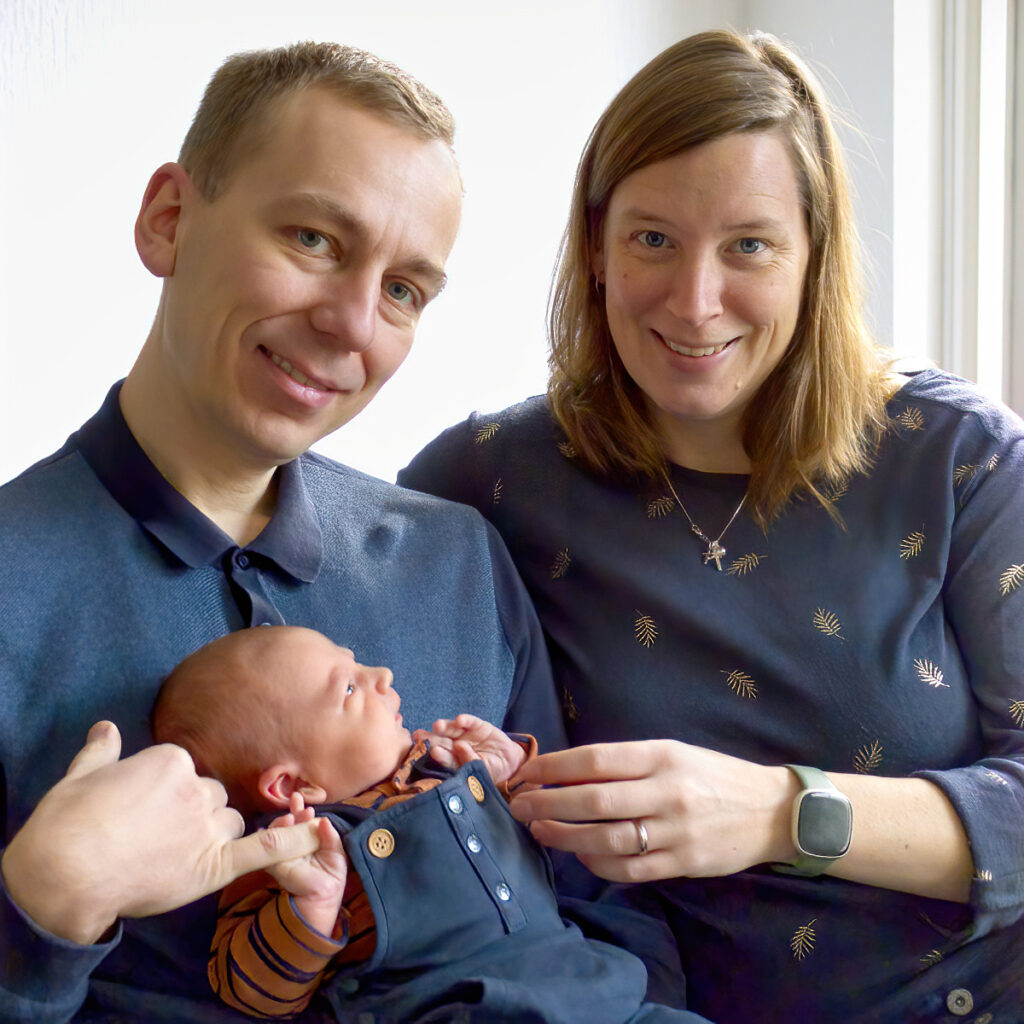 Newborn op schoot bij papa en kijkt naar mama