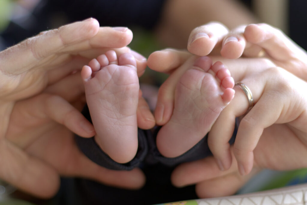 Voetjes van newborn in handen van kersverse papa en mama